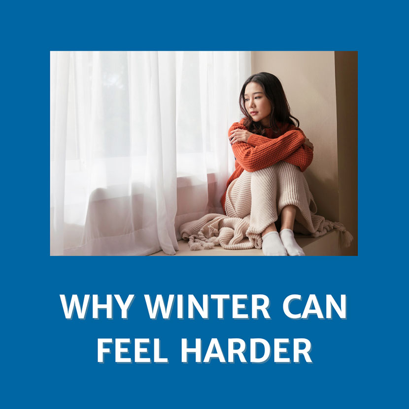 Why Winter Can Feel Harder (text) Person sitting in front a window with the drapes drawn (image)